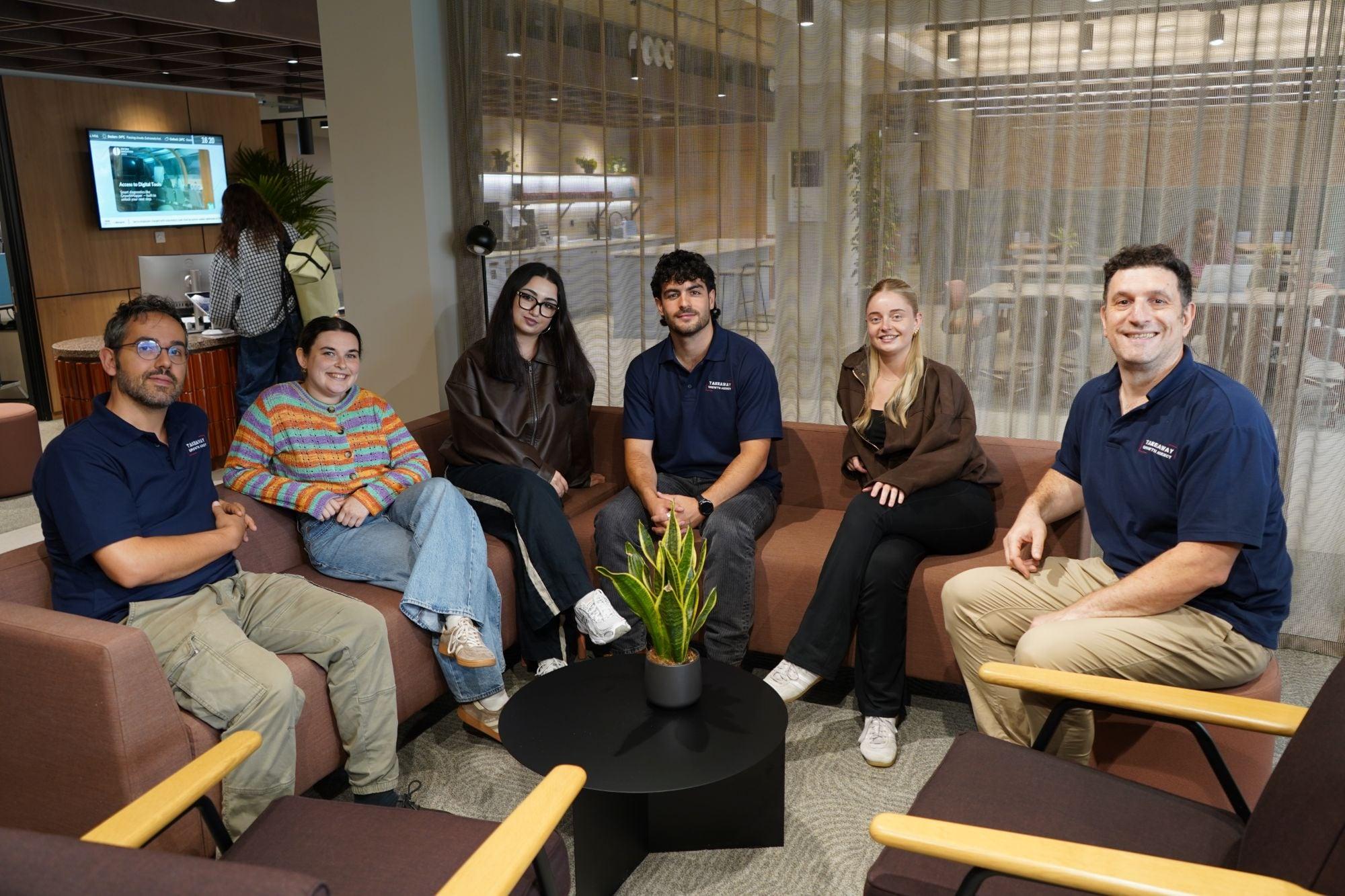 The Takeaway Growth Agency team, smiling, in matching TGA polo shirts
